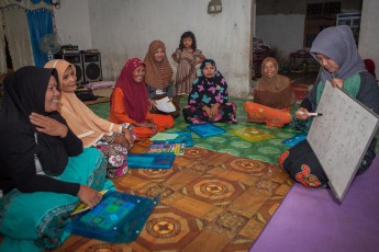 Es ist stockfinster als die ersten Frauen den Raum betreten. Eben waren sie noch zum Freitagsgebet in der Moschee. WWF-Lehrerin Antika unterrichtet Lesen und Schreiben. Für viele Frauen ist dies die erste Schule, die sie in ihrem Leben besuchen. Jede Frau im Sitzkreis liest das ABC vom Whiteboard ab, ihre Blätter füllen sie mit selbstgeschriebenen Buchstaben, viele Kinder schauen zu, einige helfen ihren Müttern und Großmüttern. Und es wird viel gelacht. Zum Schluss der Unterrichtsstunde wird reihum eine Jäger-Tiger-Geschichte gelesen, in dem sich der Tiger als Held entpuppt. So merzt man archaische Feindbilder aus.
