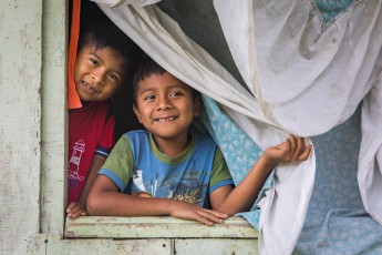 Im Dorf Jamaikari der indigenen Cabécar schauen Maximiliano und Ketelik aus dem Fenster ihres Zuhauses.