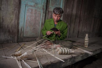 Dinh Lau, geb. 1955, gehört zur ethnischen Minderheit der Aram, die in Vietnam nur noch knapp 200 Mitglieder umfasst. Hier baut er gerade flaschenähnliche Aal-Reusen aus Bambus. Nach Gründung des Nationalparks siedelte man sein gesamtes Dorf an den Rand des Parks. Eine fragwürdiges Projekt, da es den Aram untersagt ist, für ihren Lebensunterhalt in ihrem ursprünglichen Lebensraum im Park zu jagen oder sammeln. Heute sind sie in hohem Maße von staatlichen Subventionen abhängig.