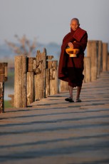 Burma/Myanmar, Amarapura, U-Bein Bridge: A monk on his way back from the morning's alms walk.
