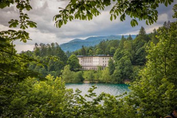 Durch das sattgrüne Blätterdach von Kastanien und Buchen schimmert die klassizistische Villa Bled - einst Sommerresidenz des Präsidenten, heute luxuriöses Hotel am Ufer des smaragdfarbenen Gletschersees.