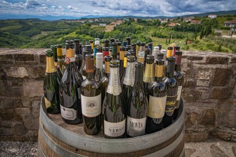 Auf einem alten Eichenfass versammeln sich die edlen Tropfen der Brda-Winzer - von mineralischen Sauvignon Blancs bis zu eleganten Chardonnays spiegelt jede Flasche das einzigartige Mikroklima - und wohl auch den Durst - dieser slowenischen Weinregion wider.