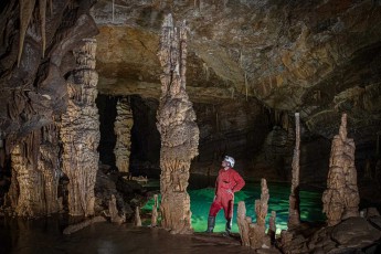 Wie ein Wächter der Unterwelt steht Gašper Modic zwischen den monumentalen Tropfsteinsäulen der Križna-Höhle. Das smaragdgrüne Wasser zu seinen Füßen reflektiert jahrtausendealte Kalkformationen und erschafft eine Szenerie von unwirklicher Schönheit.