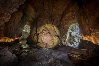 In der monumentalen Mahorčič-Höhle, einem Teil des Škocjan-Höhlensystems, wird Guide Borut Lozej zur Miniatur vor titanischen Kalksteinwänden. Tageslicht dringt durch die natürlichen Portale und verwandelt die UNESCO-Welterbestätte in eine Kathedrale aus Licht und Schatten.