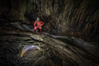 Der Reka-Fluss rauscht über geschliffene Kalksteinbänke durch die Tiefen der Škocjan Höhle. Guide Borut Lozej begutachtet ein Becken, welches durch Jahrtausende Wasserkraft und Erosion geformt wurde.