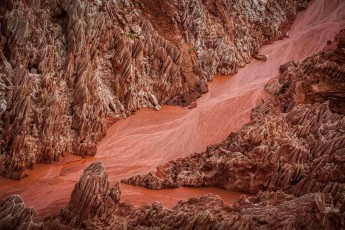 Like an alien lunar landscape, the sharp Tsingy needles stretch in spectacular ochre tones - between the limestone pinnacles reaching up to 100 metres high, iron oxide-rich sediments have deposited in brilliant reds, forming one of Earth's most bizarre karst landscapes.