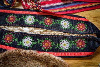 Artfully embroidered garments featuring traditional floral motifs in a historic cabin in Metis Crossing, Alberta.