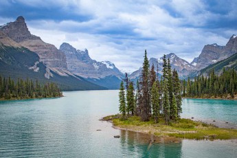 The essence of untouched wilderness: the picturesque Spirit Island rises from the turquoise waters of Lake Maligne in Jasper, Alberta, framed by the majestic peaks of the Canadian Rockies.