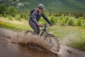 Mountain bike guide Paul Flavell is completely in his element: surrounded by the breathtaking scenery of the Rocky Mountains near Canmore, he skilfully races through a huge puddle.