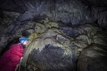 Annie Hewitt examines calcite formations in Rat's Nest Cave near Canmore. The metre-high sinter formations and flowstones were created an unimaginably long time ago, as calcite only grows about 2.5 cm per millennium.