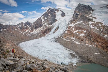 Jennifer Malloy pauses as the Zillmer Glacier pushes white tongues of ice down fractured rock toward a meltwater lake below.