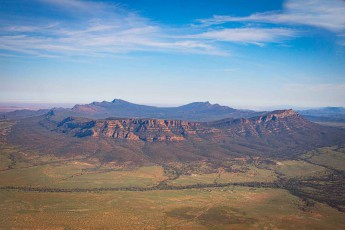 Wilpena Pound: Sedimentschichten stapeln sich in ockerfarbenen, rostbraunen und violetten Bändern zu einem amphitheatergleichen Krater - eine steinerne Schale im ausgedörrten Outback.