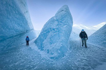 Ein einzelner Eisturm teilt die Schlucht, links und rechts führen die Wege daran vorbei – der Boden ist blankes Eis, begehbar nur mit Grödeln unter den Sohlen.