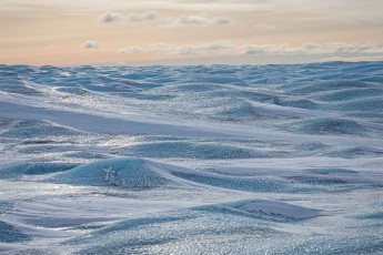 Die Eiskappe, gewellt wie eine erstarrte Dünung bis zum Horizont – im Landesinneren wird der grönländische Eisschild über drei Kilometer dick.
