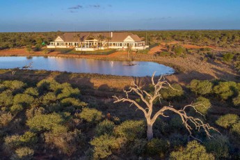 Aus der Luft: Das Shaturia Manor thront über einem Wasserloch, davor reckt ein abgestorbener Baum seine weißen Äste – eines der vier Häuser von Lotsane (Foto von Lotsane Lodge).