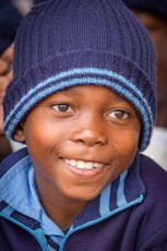 Breites Lachen unter der Strickmütze – ein Schüler der Moletemane Primary School schaut der Vorführung zu.