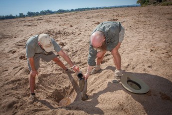 Nep und Bruce schöpfen Wasser aus einem Loch im Limpopo River. Das Wasser ist unbedenklich und kann sofort getrunken werden.