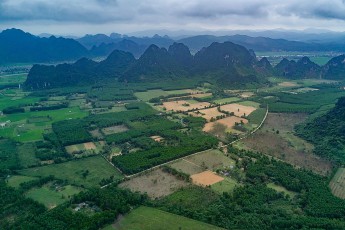 Reis- und Gemüseanbaufelder bei Phong Nha. Die Region gehört zu den schnell wachsenden Touristendestinationen Südostasiens. Das liegt unter anderem an den leicht zugänglichen und prächtigen Schauhöhlen Phong Nha Cave und Paradise Cave. Bis heute hat man in der Umgebung über 230 Höhlen entdeckt und vermessen. Viele weitere werden noch in den abseits gelegenen Arealen des Nationalparks vermutet.