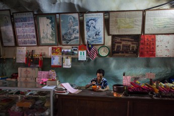 Eine Devotionalienverkäuferin genießt Ihre Mittagssuppe in einer der zahllosen Höhlen Malaysias.