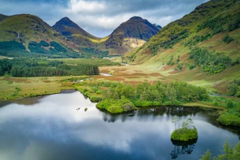Lochan Urr: Ein idyllischer See, ein üppiges Wäldchen, majestätische Berge - schottisches Hochland in seiner ganzen Pracht.