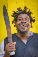 Boom Boom, drum teacher in Hopkins, raises the machete he uses to split coconuts every day.