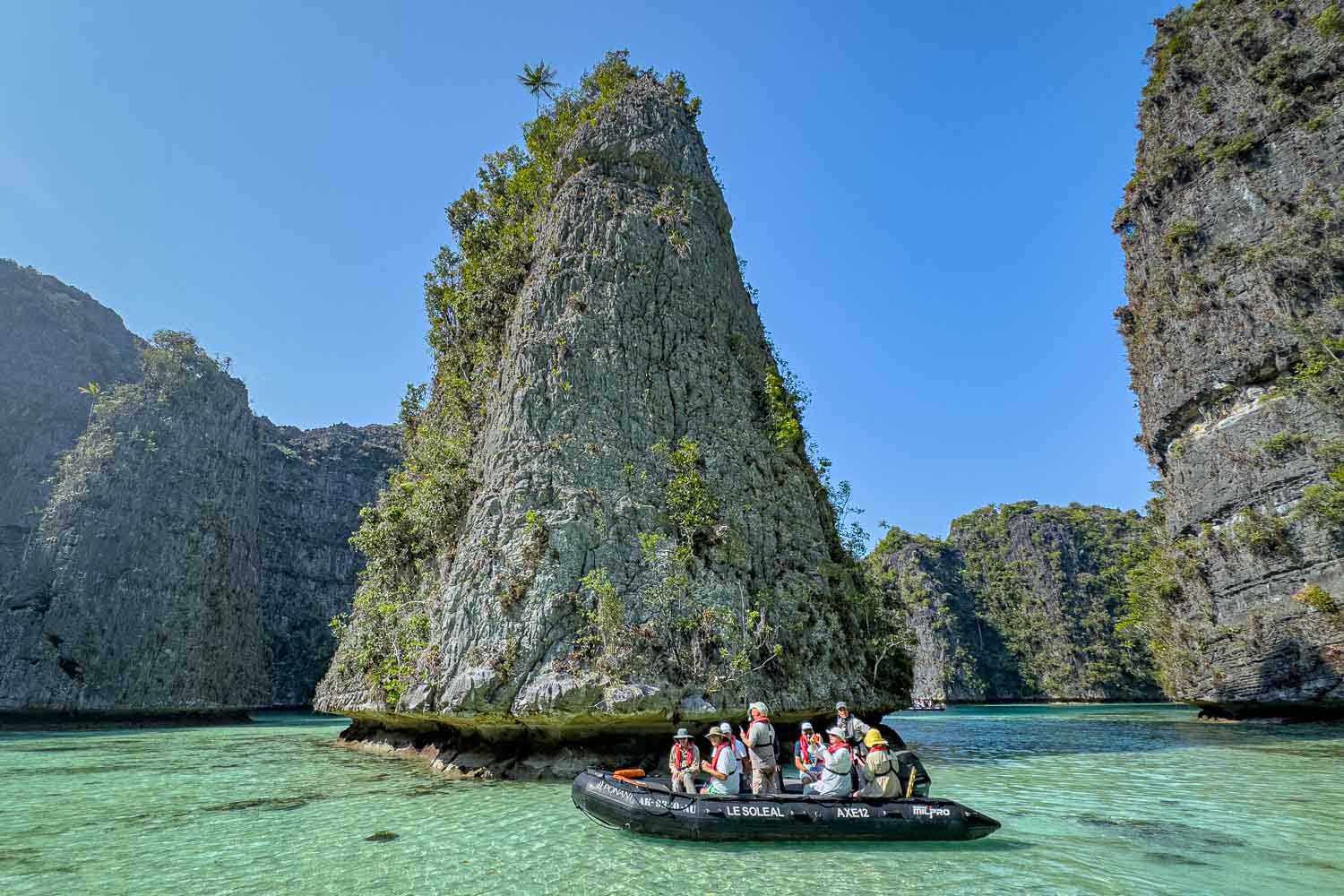 Zodiac der Le Soleal an einem Karstturm in der Lagune von Misool.